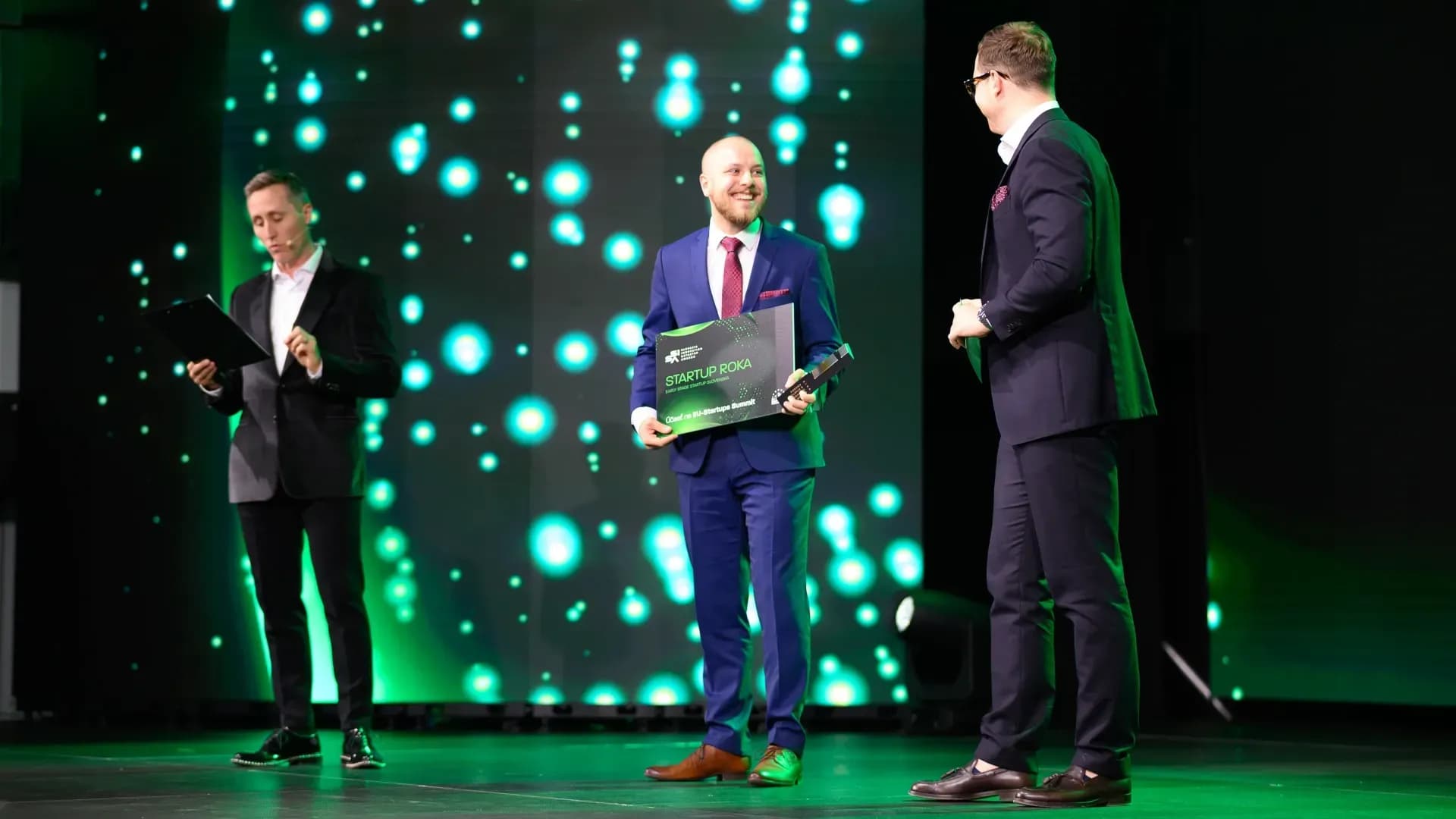 OWASmooth founder Miro holding a green award after winning the SISA on a modern green background
